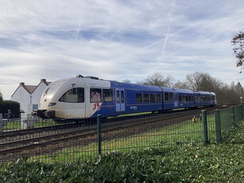 foto van een blauw witte trein op het spoor