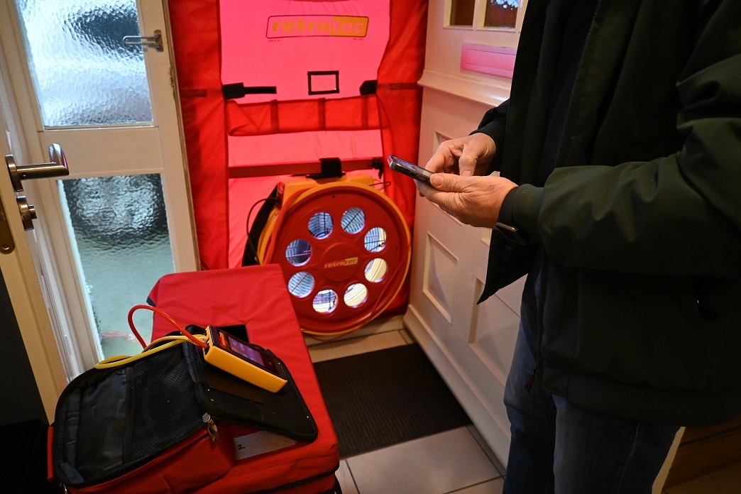 Foto van een blowerdoor dat is een grote ventilator in de deur bootst een flinke windkracht na, waardoor via kieren in huis koude lucht naar binnenkomt